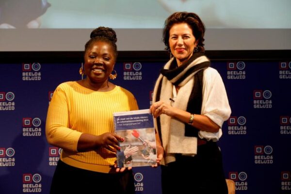 Voorzitter-van-het-Commissariaat-Amma-Asante-overhandigt-aan-staatssecretaris-voor-Cultuur-en-Media-Gunay