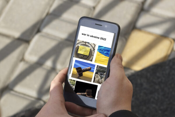 A young man reads news about the war in Ukraine in 2022.